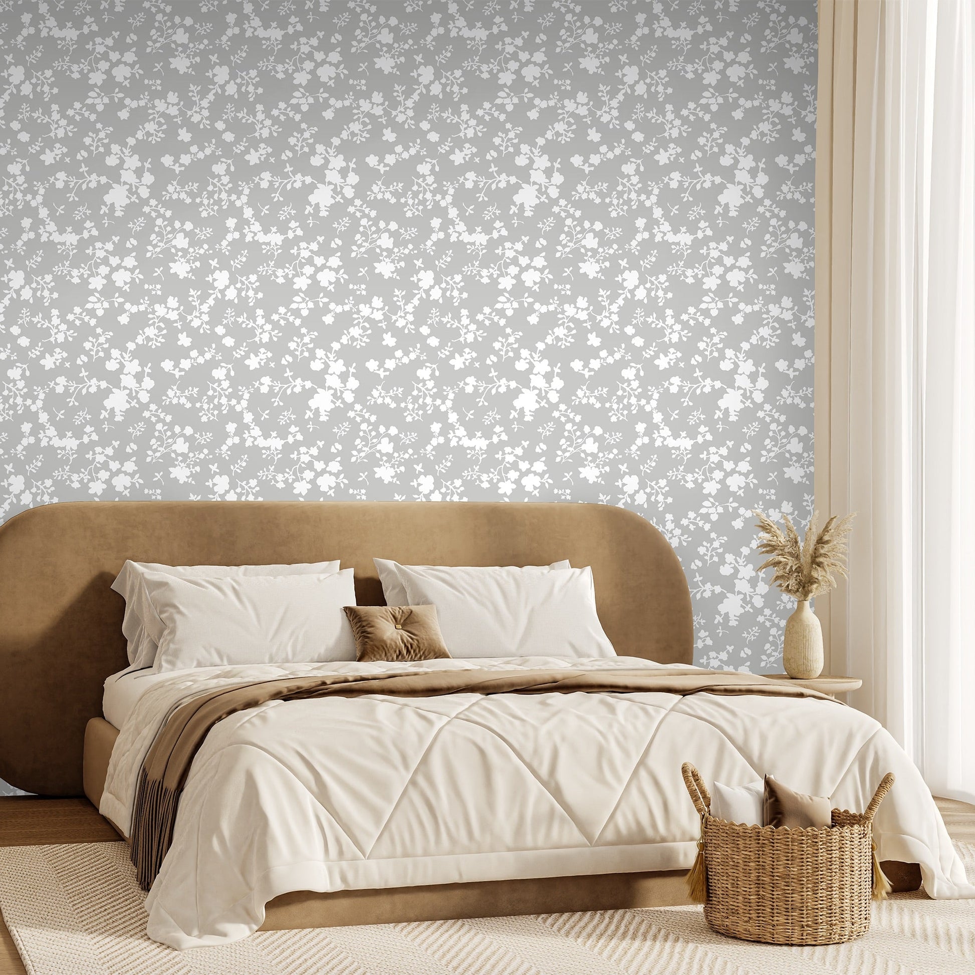 Modern bedroom with a brown upholstered bed and decorative pillows against a modern floral knockout style wallpaper in a warm grey and white
