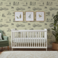 Green wallpaper in a boy's nursery featuring mountain ranges, bears, tents, trees and canoes. 