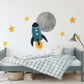 a child's bedroom with a bed and a rocket wall decal