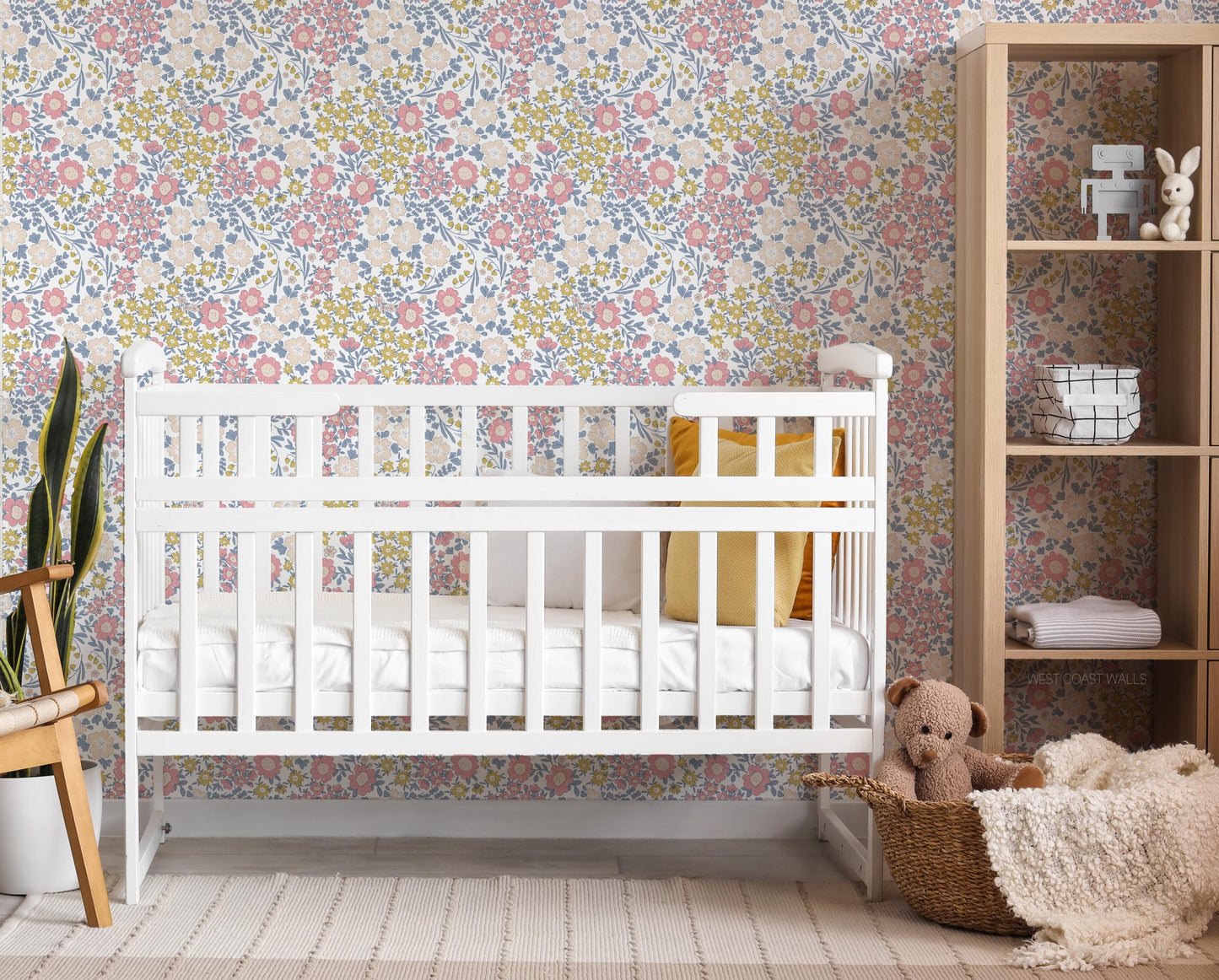 Dainty pink and yellow floral wallpaper with blue accents in a nursery