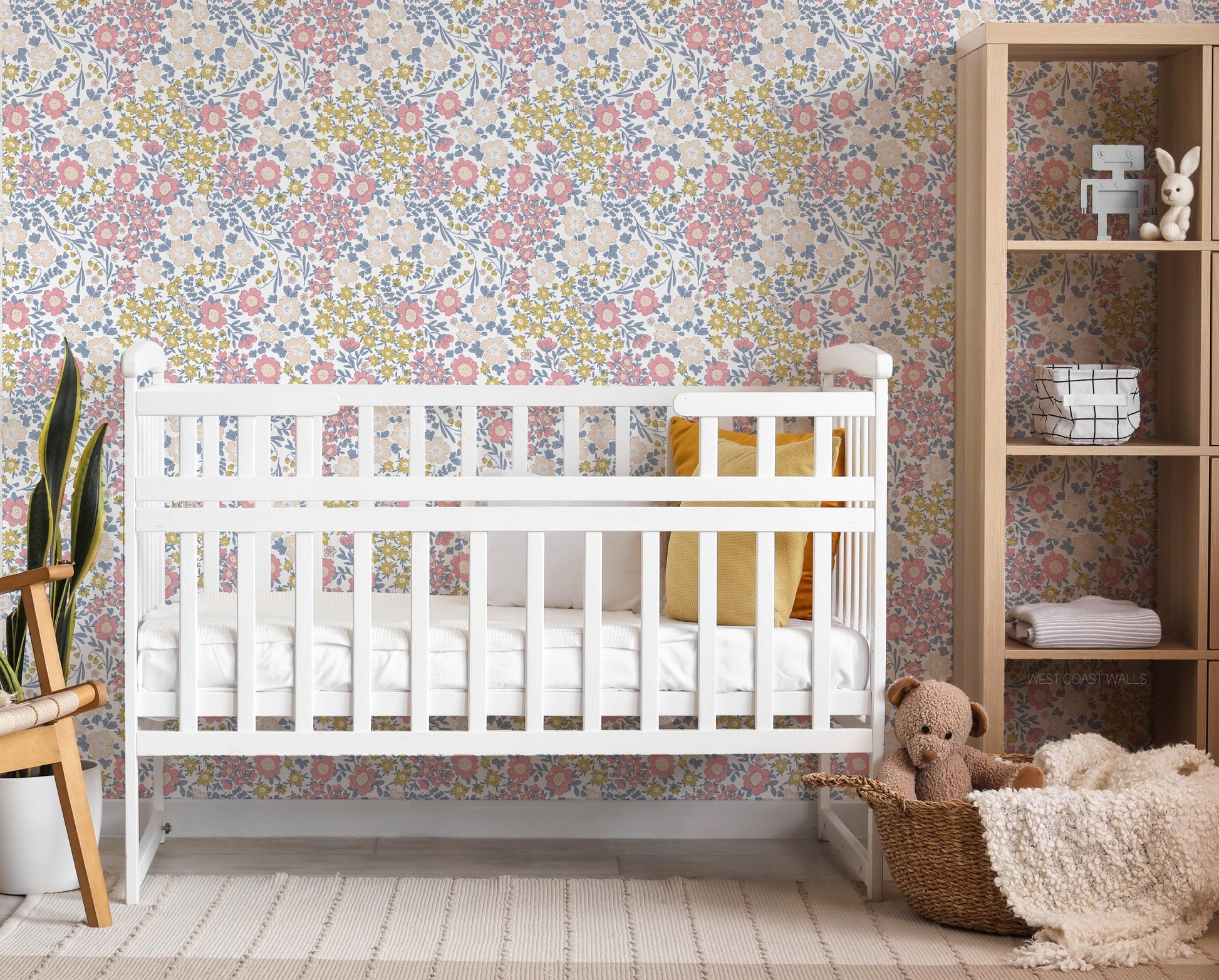 Dainty pink and yellow floral wallpaper with blue accents in a nursery