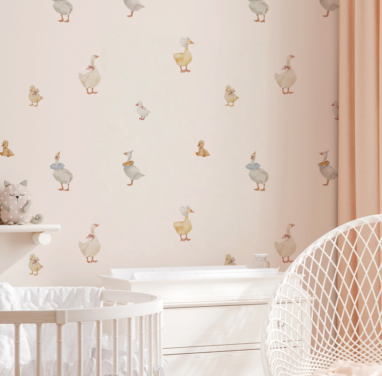 A nursery wall in soft pink tones is decorated with watercolor style duck and goose wall decals