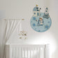 A nursery wall decal featuring a cartoon astronaut, space station, and rocket on a blue moon, shown above a white crib with a white canopy and cloud mobile.