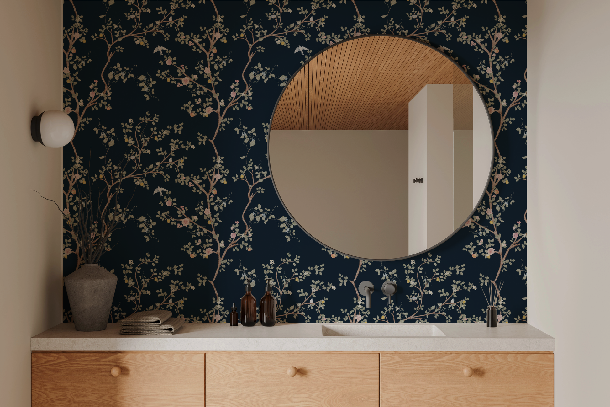 Modern bathroom with round mirror on floral branch wallpaper with navy background